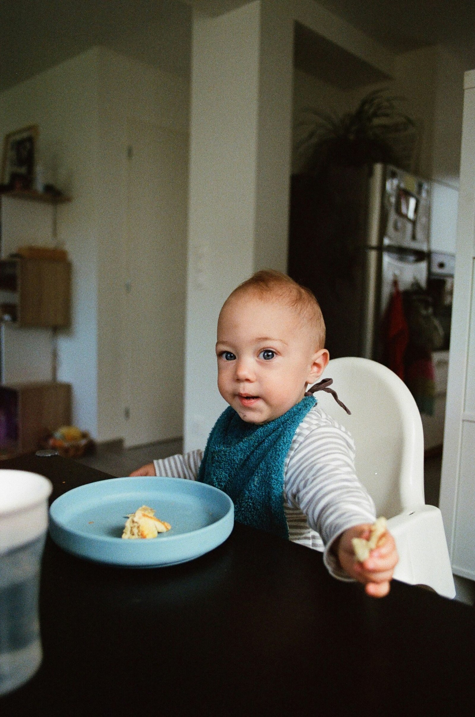 Baby in an infant comfort seat with ‘Happy Birthday’ banner in the background.